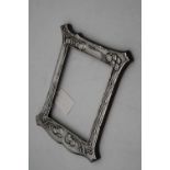An Art Nouveau silver clad easel photograph frame, of shaped rectangular form, having sinuous floral