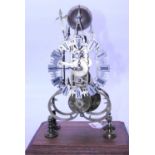 A Victorian brass cathedral type skeleton clock having silvered shield shaped Arabic markers, the
