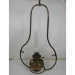 An early 20th century brass hanging oil lamp, the burner marked 'Lampe Veritas', within a bell