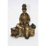 A modern bronze alloy figure of an eastern deity in seated pose upon a dog of fo, height 29cm