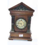 An early 20th century continental walnut cased mantel clock, of architectural form, height 31cm