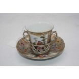 A 19th century Berlin porcelain trembleuse, the twin handled cup decorated with opposing reserves of