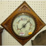 An Edwardian floral relief carved oak aneroid barometer, housed in integral lozenge surround