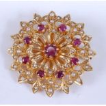 A yellow metal, ruby and pearl circular cluster brooch, comprising nine round faceted rubies and