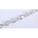 A white metal moonstone bracelet, with fourteen oval cabochon cut moonstones, in bezel settings with