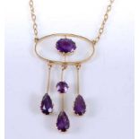 A yellow metal amethyst openwork pendant, comprising a centre oval faceted amethyst with three