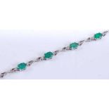 A white metal, emerald and diamond line bracelet, comprising eight oval faceted emeralds with a