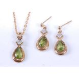 A yellow metal, peridot and topaz pendant and earring set, the earrings each with a pear cut peridot