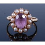 A yellow metal, amethyst and pearl oval cluster ring, featuring a centre oval amethyst within a