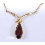 A yellow metal, garnet and diamond necklet, comprising an articulated wishbone pendant with a pear