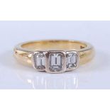 An 18ct yellow and white gold diamond three stone ring, comprising three graduated emerald cut