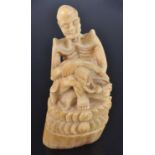 A late 19th century Indian ivory figure, carved as a skeletal male with elongated ears in seated