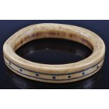 An early 20th century North African bangle, of mishapen oval form inlaid with two metal bands and