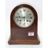 An Edwardian mahogany and chequer strung cased mantel clock having a silvered dial with Roman