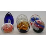 A collection of six various glass paperweights