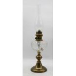 An early 20th century brass pedestal oil lamp, having a cut clear glass font, h.60cm (including
