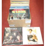 A box of vintage records, to include Queen Greatest Hits, Wham! Make It Big, The Beach Boys