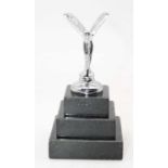 A reproduction chromed figure of the Spirit of Ecstacy mascot on stepped square plinth, height 13cm