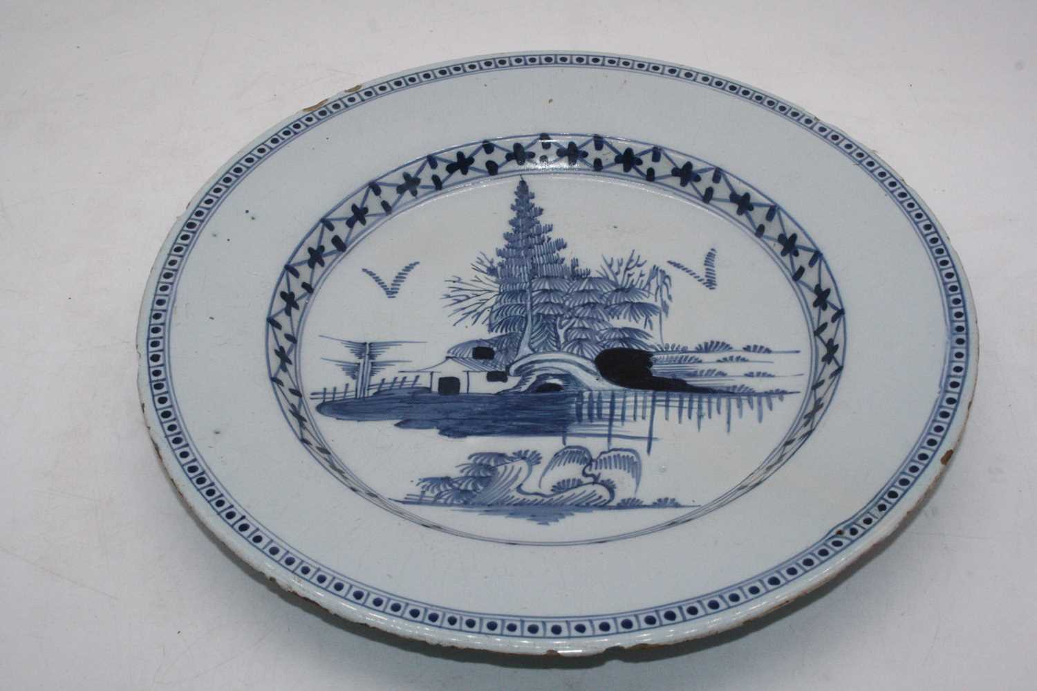 An 18th century English Delft blue & white charger, the centre underglazed decorated with trees - Image 3 of 3