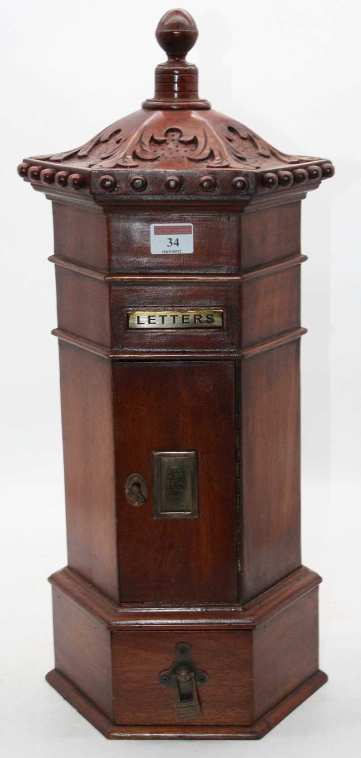 A Victorian style country house type pillarbox letterbox of hexagonal form having a turned finial