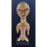 An early 20th century African ivory figure, carved as a male in standing pose engraved with circles,