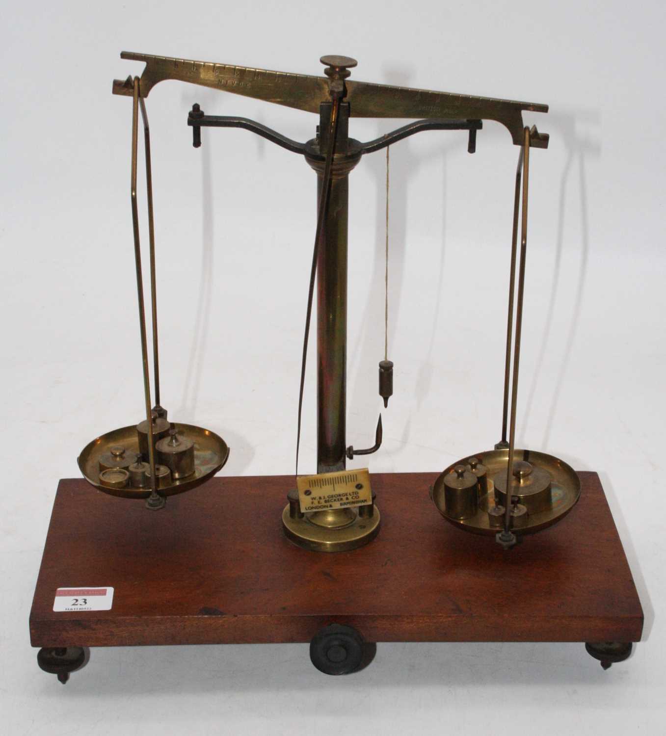 A set of Victorian brass beam scales, on mahogany plinth, bearing a plaque for W&J George Ltd, FE