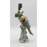 A reproduction continental porcelain candlestick in the form of a parrot perched on a treestump, h.