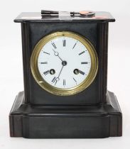 An Edwardian black slate cased mantel clock having a circular enamelled dial with Roman numerals and