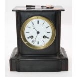 An Edwardian black slate cased mantel clock having a circular enamelled dial with Roman numerals and