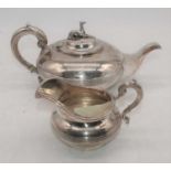 A Victorian silver teapot and cream jug, each of squat central banded form, with S-scroll handles (
