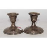 A pair of Fisher sterling silver rose bouquet pattern weighted dwarf table candlesticks, height 9cm