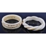 An early 20th century ivory bangle with carved ropetwist decoration, dia.8.5cm, together with an