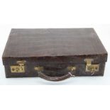 An early 20th century crocodile skin travel case, the leather lined interior with address book,