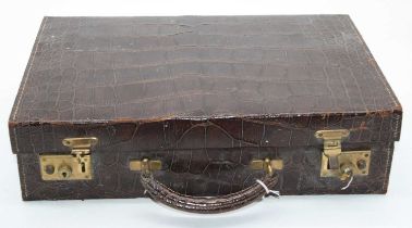 An early 20th century crocodile skin travel case, the leather lined interior with address book,