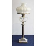 A Victorian oil lamp, having opalescent moulded glass shade above a clear glass font, on a fluted