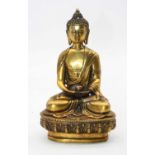 A reproduction gilt metal Tibetan deity in typical seated lotus pose,height 20cm