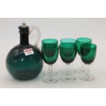 An early 20th century green glass drinks set, comprising a carafe and six drinking glasses