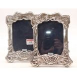 A pair of Art Nouveau style silver clad easel photograph frames, each repoussee decorated with