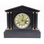 A late Victorian black slate mantel clock, of architectural form, having a enamelled chapter ring