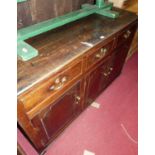 An 18th century provincial oak dresser base, having three frieze drawers over conforming cupboard