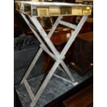 A contemporary mirrored glass twin handled drinks tray, raised on folding stand, width 46.5cm