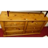 A contemporary pine six drawer fitted sideboard, raised on bun supports, w.150cm