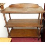 A late Victorian oak three-tier buffet whatnot, having a scroll edged back and raised on turned