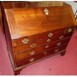 An early 19th century mahogany slopefront writing bureau, having a fitted interior over three