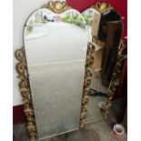 A pair of 1930s bevelled arched wall mirrors, each having pierced and gilt floral stylised