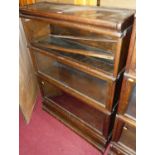 A 1920s oak three-tier stacking bookcase, having typical hinge glazed doors (one requires repair and
