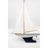 A mid 20th century blue & white painted model of a pond yacht with sails and rigging on pine