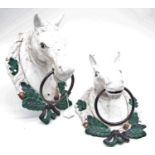 A pair of large cast iron and painted door knockers each in the form of a horse head within a