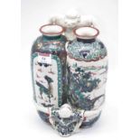 A Japanese vessel in the form of two vases being held together by two figures top & bottom, the