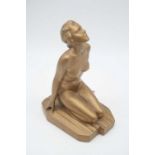 An Art Deco gold painted plaster model of a female nude in kneeling pose, the plinth impressed